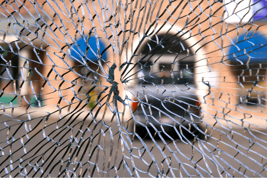 visual of a broken glass window from the inside looking out