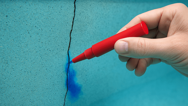 Swimming pool dye pen being used in pool skimmer.