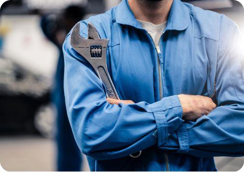 maintenance man with arms crossed holding a wrench